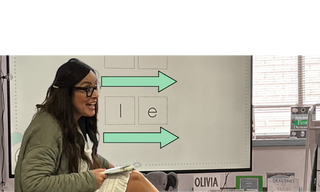 Lucía in a classroom  leading a lesson using an Hola phonic deck on the smart board.