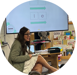 Lucía in a classroom  leading a lesson using an Hola phonic deck on the smart board.